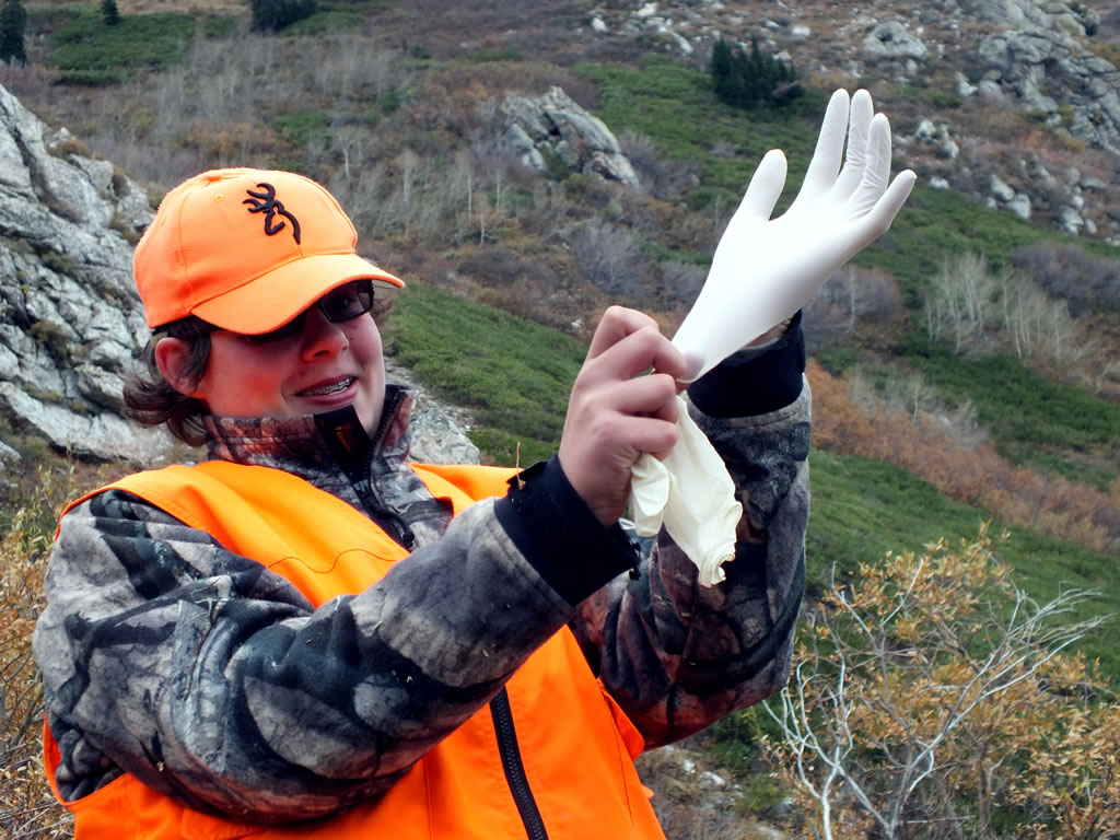 Dallen putting on the latex gloves to help his old man with boning out the mule deer